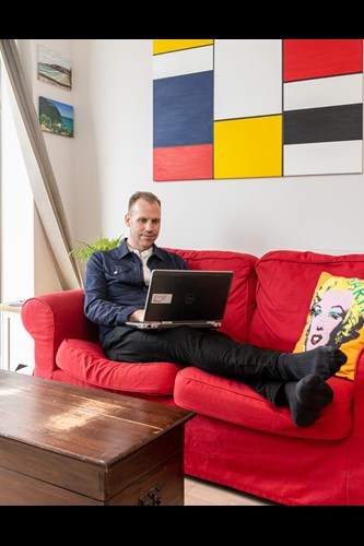 Ryan on his laptop while relaxing in the living room.